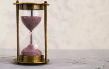 분홍색 모래가 떨어지고 있는 황동 모래시계